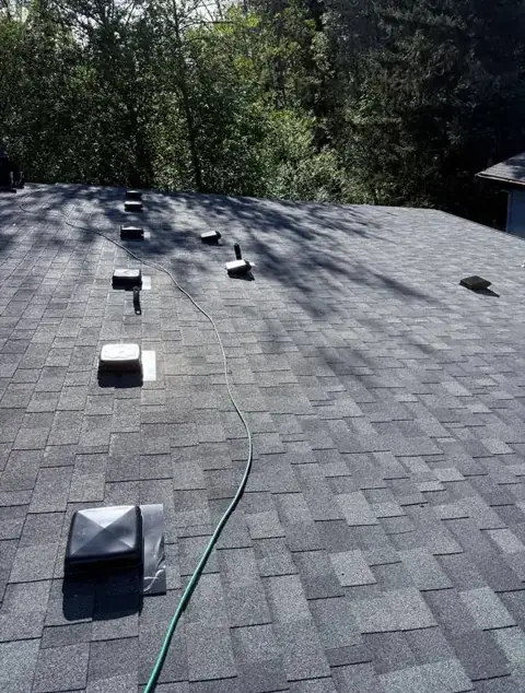 Completed gray shingle roof with vents after installation