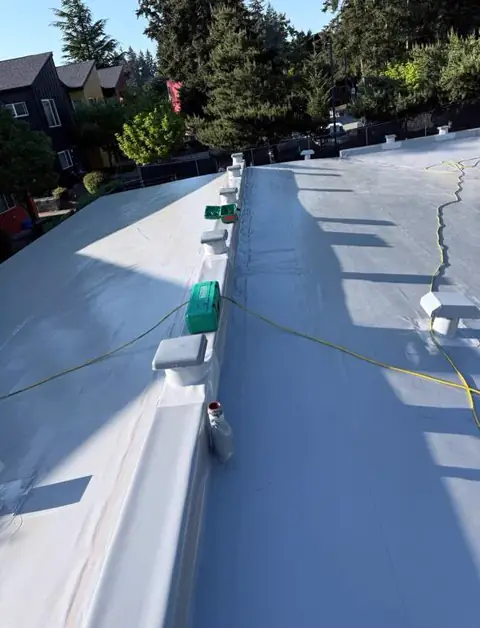 Completed white low-slope roof membrane and sealed curb details